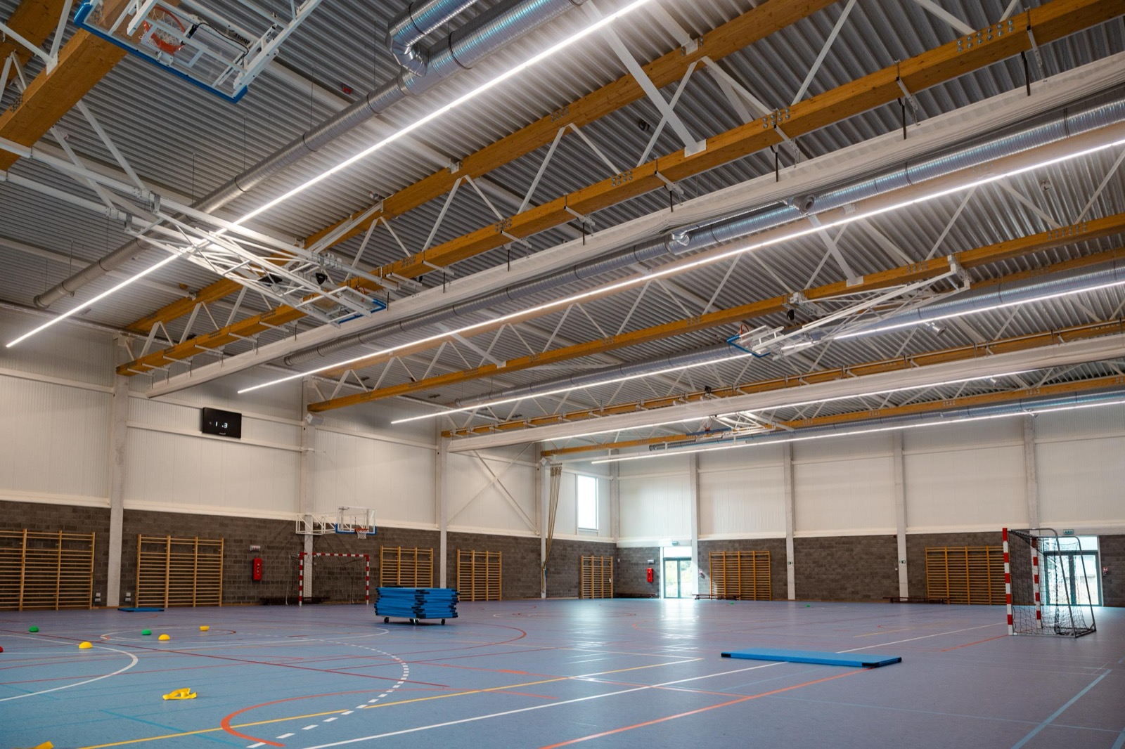 Nieuwe sporthal met zichtbare ventilatiekanalen in het dak